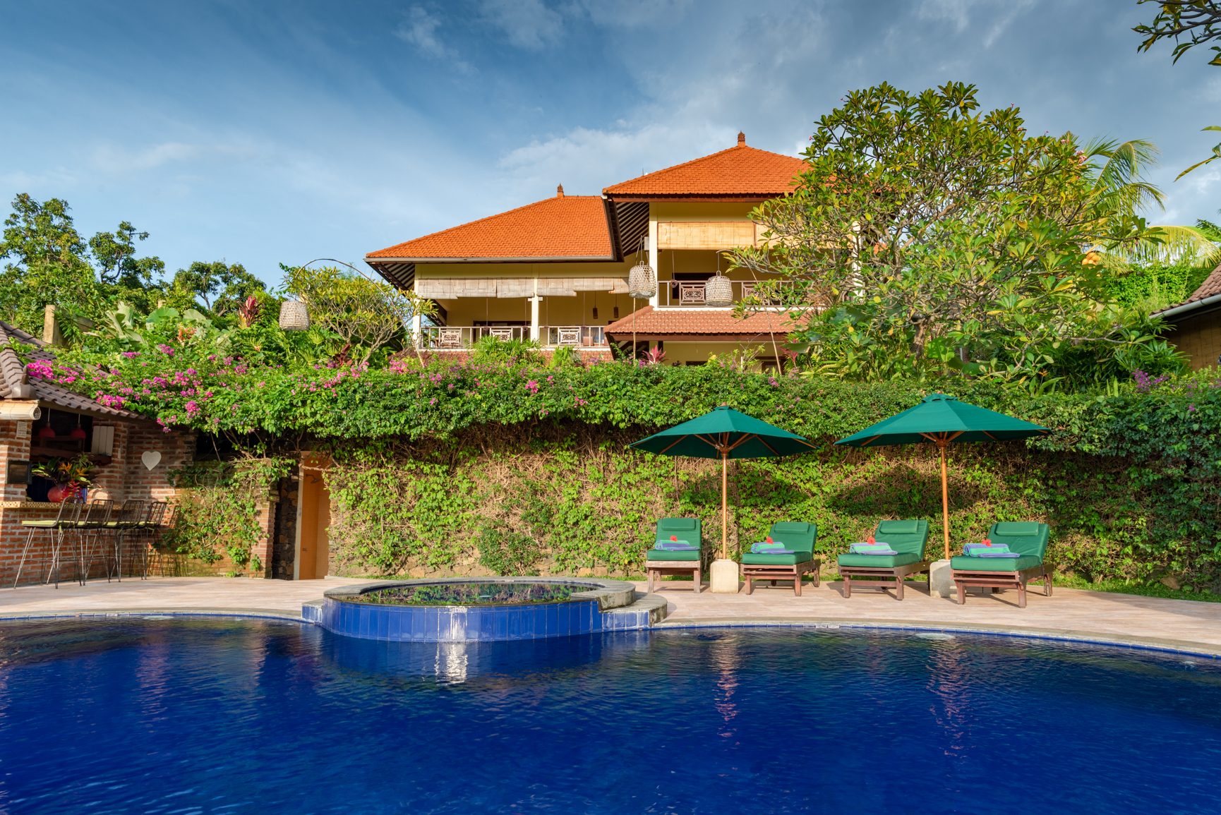 Alamanda infinity pool with the villas and North Bali hills behind