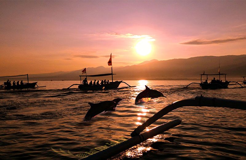 Traditional jukung boat on the Bali Sea at sunrise during a Lovina dolphin trip