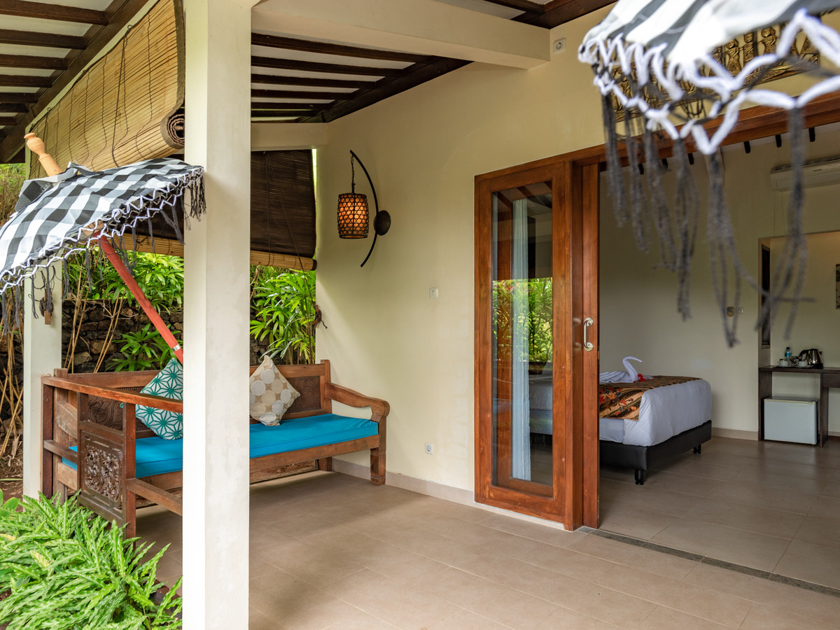 Private patio of Bungalow Ikan with seating and a view into the bedroom